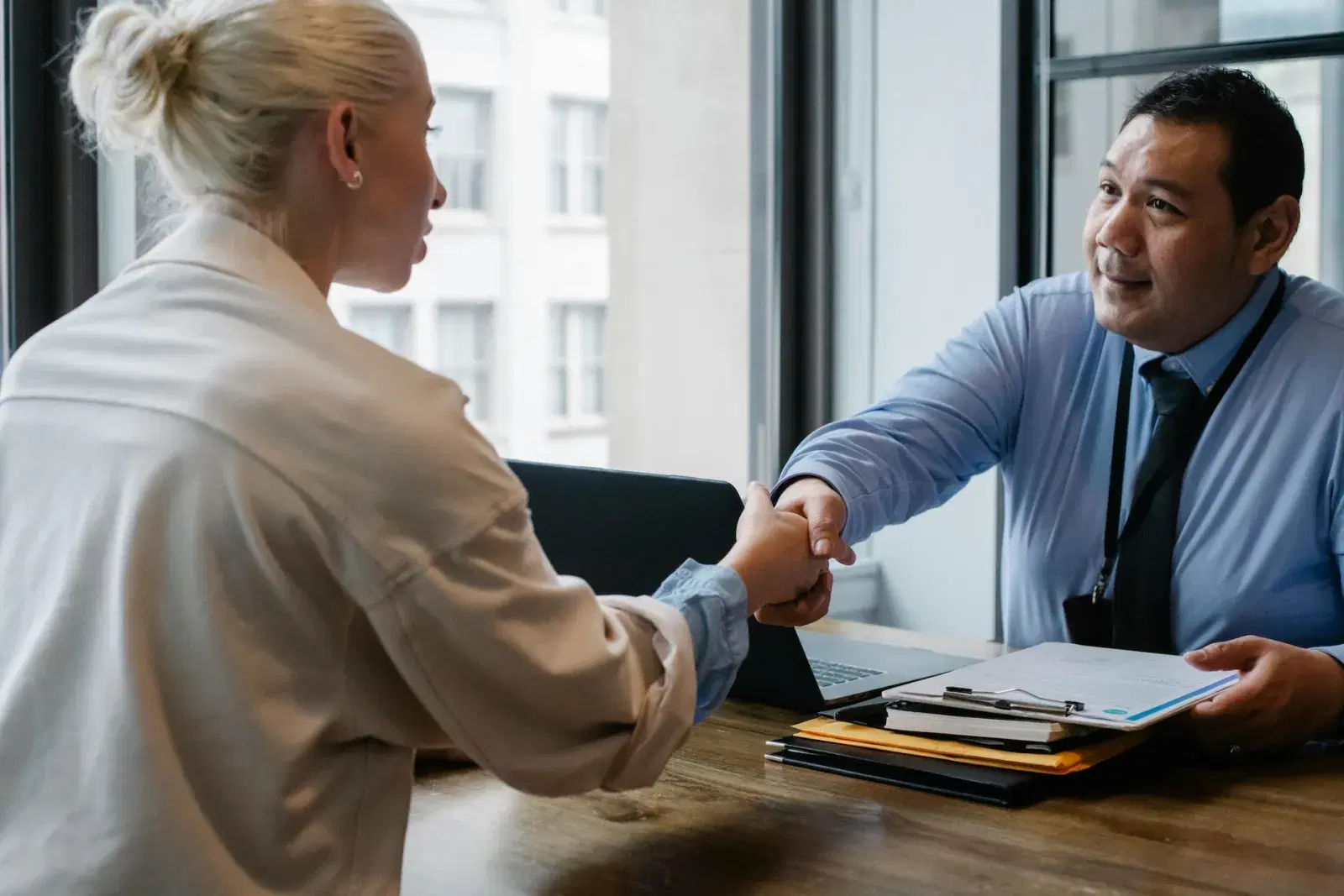A handshake across a table at a job interview
